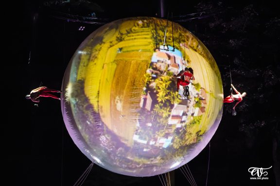 danse en harnais Deux artistes de cirque évoluent à l'intérieur d'une grande bulle transparente.