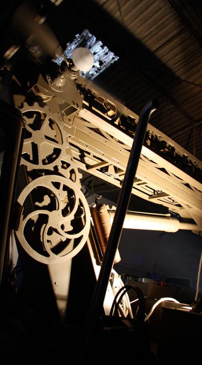 décor de spectacle Machine ancienne avec rouages, visible dans un éclairage tamisé.