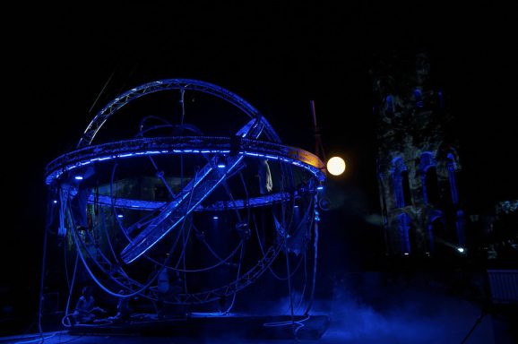 sphère armillaire geante Sculpture lumineuse en métal avec effet de néon, décor nocturne.