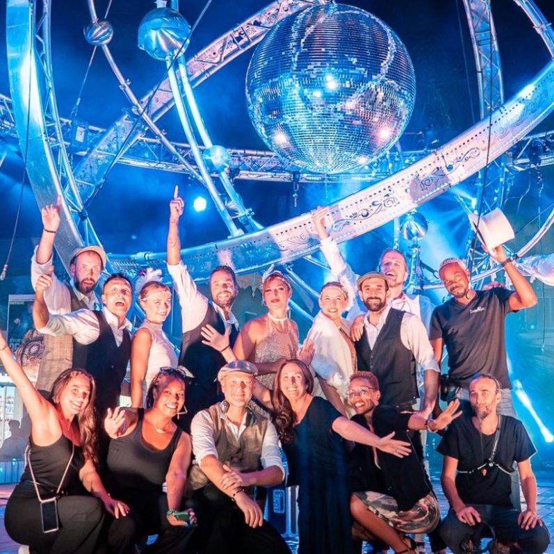 équipe deus ex machina Groupe d'artistes cabaretsouriantes en fête avec une boule à facettes en arrière-plan.