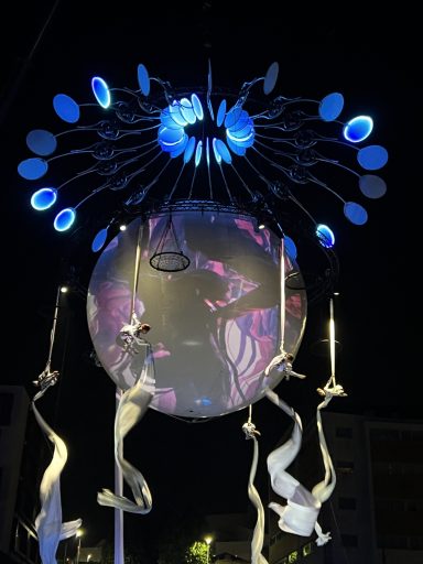 structure décor art de rue Installation artistique lumineuse avec projections et motifs colorés au centre.