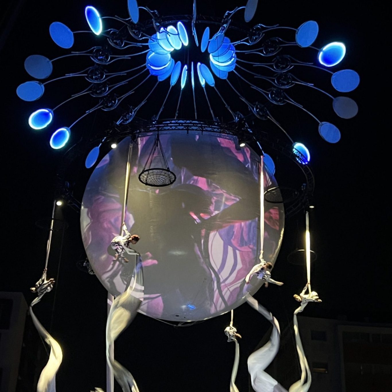 aerial performence Deux artistes acrobates suspendus dans les airs, manipulant des tissus blancs.