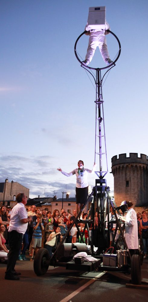 machinerie de spectacle Artiste acrobatique sur une structure mécanique, silhouetté contre le ciel au crépuscule.