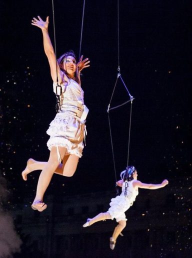 danseuses qui volent Deux artistes en suspension dans les airs, vêtues de costumes scintillants.
