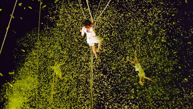tempête de confetti Une personne suspendue dans les airs, entourée de confettis colorés.