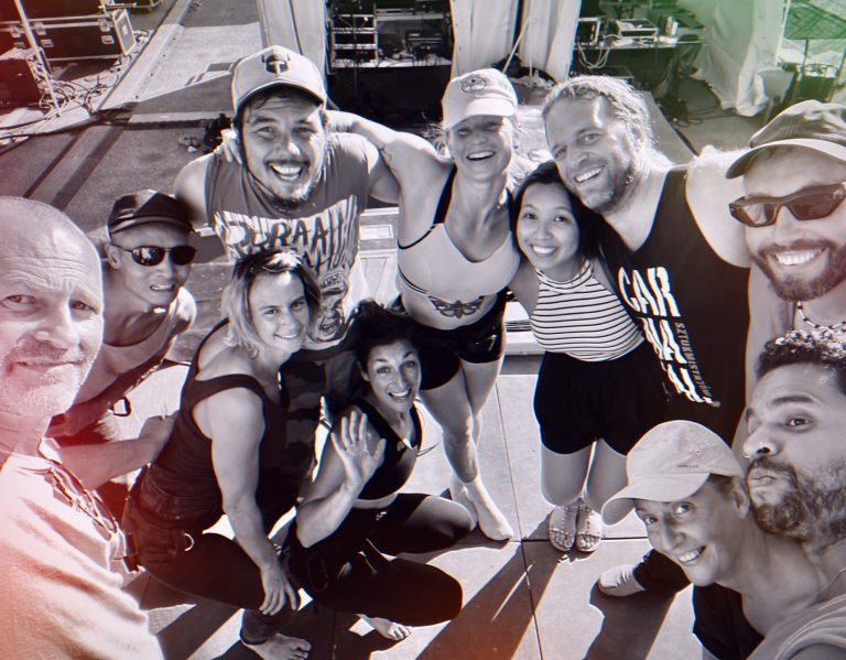 artistes cirque Groupe de dix personnes souriantes, posant ensemble sur un bateau au soleil.