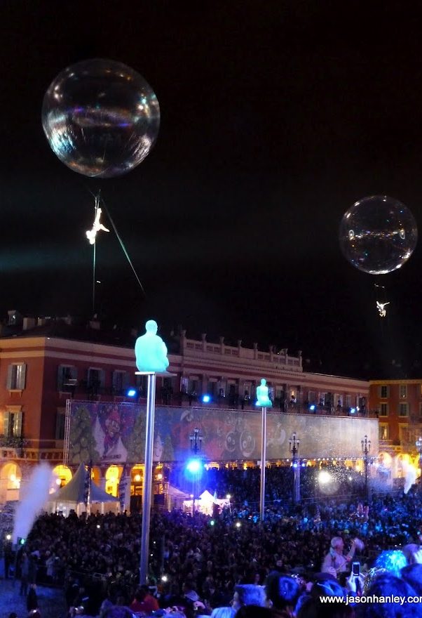 ouverture Carnaval de Nice Festival nocturne avec des bulles flottantes et une foule en dessous.