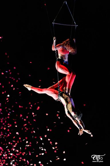 artistes aeriens Deux artistes acrobates suspendus, en apesanteur, avec des confettis au sol.