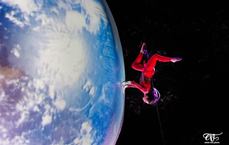 Aerial dance Un astronaute en combinaison rouge flotte près de la Terre vue de l'espace.