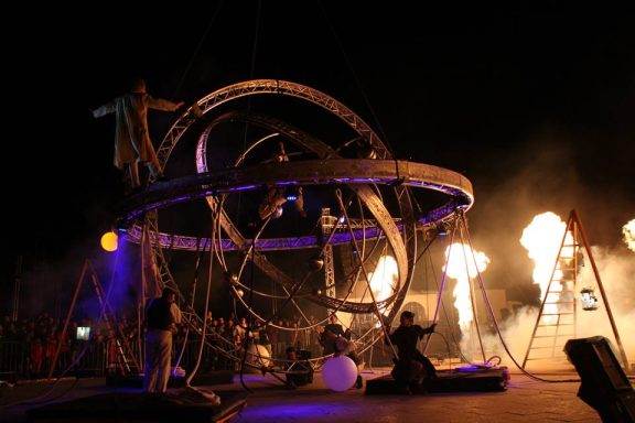 art de rue galileo Spectacle de feu avec des artistes sur scène devant un public enthousiaste.