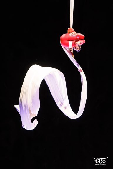 aerial silk Nœud de tissu suspendu, enroulé, de couleur blanche sur fond sombre.