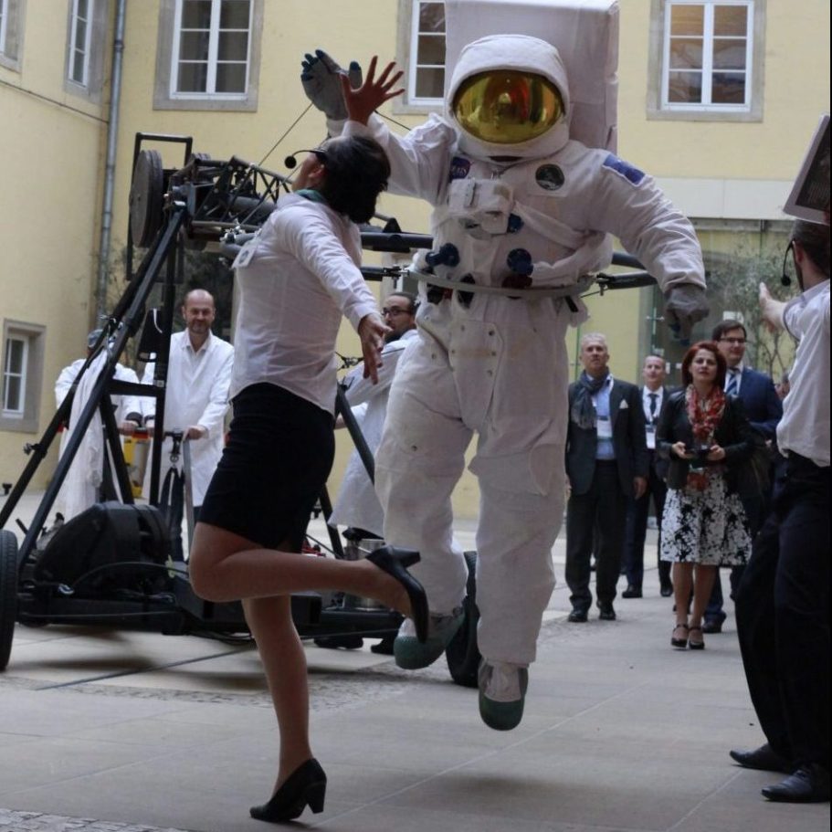 déambulation, parade lumineuse Une femme en tailleur court en sautant près d'un astronaute en combinaison spatiale.