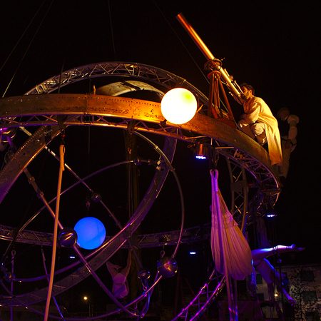 Galileo sphere aerienne geante Structure complexe représentant un système astronomique, illuminée de couleurs vives.
