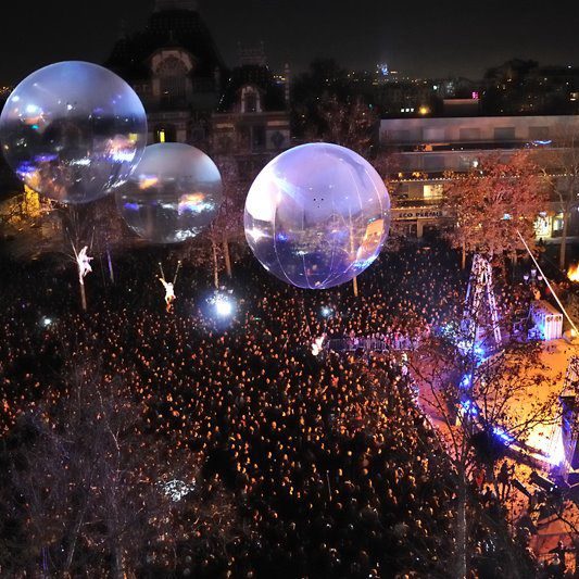 fête des lumieres Lyon Foule massée sous des sphères transparentes lors d'un événement nocturne.